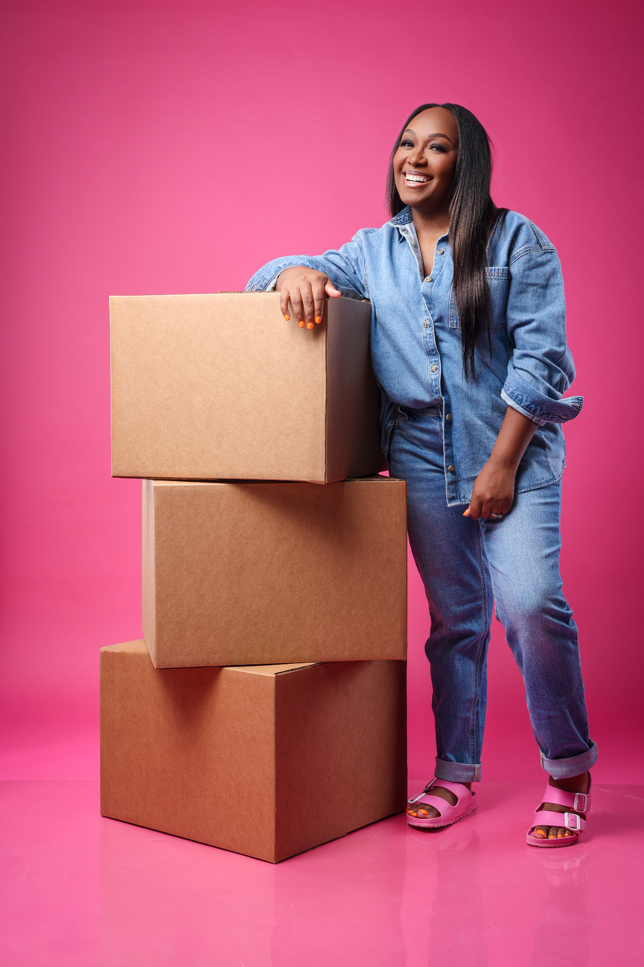 Jance Chartae leaning on a stack of inventory boxes